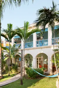 Two-Bedroom Casita exterior at Boardwalk Boutique Hotel Aruba surrounded by palm trees and tropical gardens.