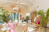 Bright, tropical-style lobby at Boardwalk Boutique Hotel Aruba with plants, seating area, and airy high ceiling.