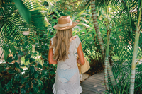 Guest walking along a tropical garden pathway at Boardwalk Boutique Hotel Aruba