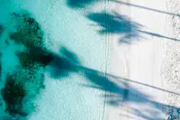 Aerial view of Aruba’s turquoise ocean and white-sand shoreline at palm beach 