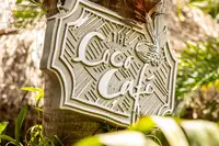 The Coco Café sign at Boardwalk Boutique Hotel Aruba in a lush tropical setting.