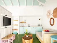 Coco Deluxe Casita kitchenette and lounge area at Boardwalk Boutique Hotel Aruba with airy tropical interior.