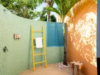 Coco Deluxe Casita outdoor shower area with privacy wall and tropical design at Boardwalk Boutique Hotel Aruba.