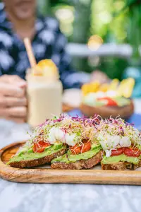 Breakfast at The Coco Café at Boardwalk Boutique Hotel Aruba with avocado toast and a smoothie.