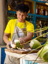 Staff preparing fresh coconuts at The Coco Café at Boardwalk Boutique Hotel Aruba.