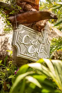 The Coco Café sign at Boardwalk Boutique Hotel Aruba in a lush tropical setting.