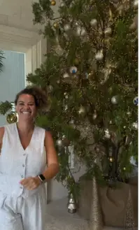 Team member decorating the Christmas tree at Boardwalk Boutique Hotel Aruba, creating a warm holiday welcome for guests.